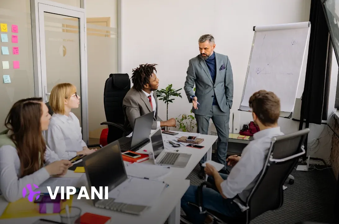 Manager presenting to an engaged team around an office meeting table