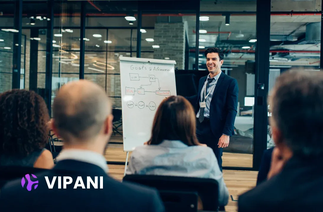 Leader presenting at a whiteboard to a team in a meeting room